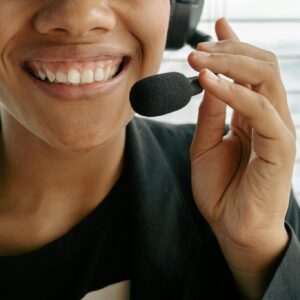 Close Up Photo of a Smiling Woman Holding Microphone