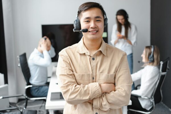 Smiling Man in Brown Long Sleeve Shirt Wearing Headphones